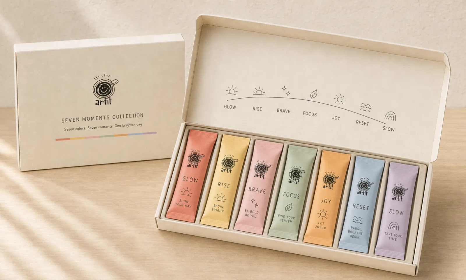The Seven Moments Collection box open on a table — seven colored sachets in a row, with all seven names and their drawings printed inside the lid